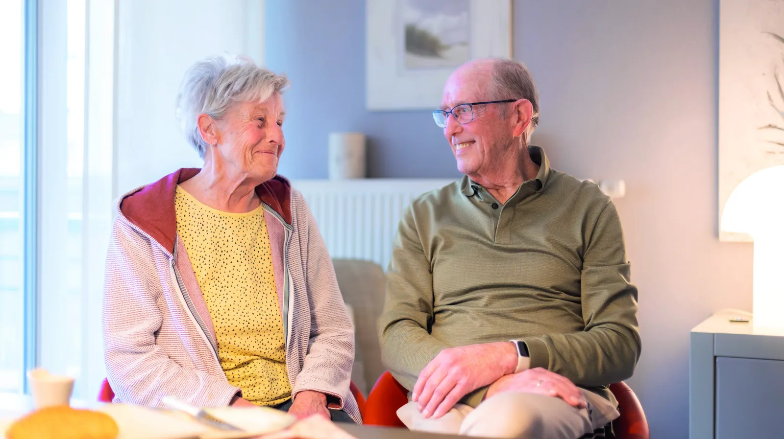 Maria und Willi Sommer lachen gemeinsam in ihrem Wohnzimmer