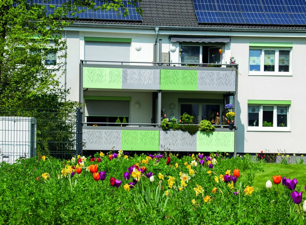Wohnhaus mit blühender Blumenwiese davor