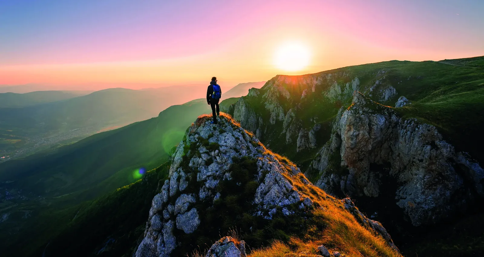 Wanderer auf einem Berggipfel bei Sonnenaufgang